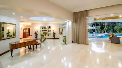 a living room with a piano and a pool at Villa Christies at 32 on Russell in Nelspruit