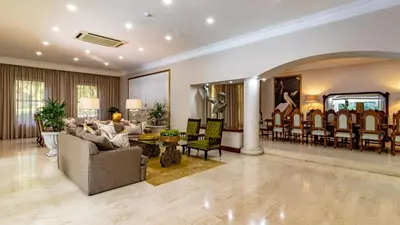 a living room with a couch and a dining room at Villa Christies at 32 on Russell in Nelspruit