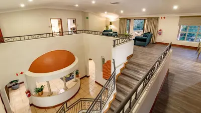 an empty lobby with a spiral staircase in a house at Villa Christies at 32 on Russell in Nelspruit