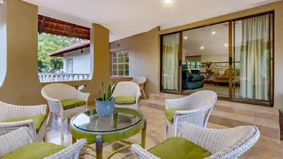 a living room with chairs and a glass table at Villa Christies at 32 on Russell in Nelspruit