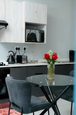 a kitchen with a glass table with flowers on it at Stunning 1 bed in Midrand at 93 On New Estate in Midrand