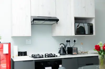 a kitchen with white cabinets and a stove top oven at Stunning 1 bed in Midrand at 93 On New Estate in Midrand