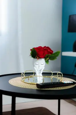 a vase with a rose in it on a table at Stunning 1 bed in Midrand at 93 On New Estate in Midrand