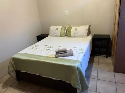 a bedroom with a bed with a green and white comforter at AS contractors accommodation in Erasmus