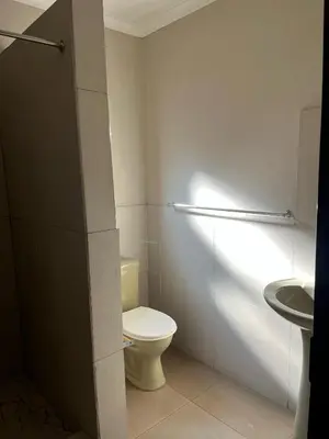 a white bathroom with a toilet and a sink at AS contractors accommodation in Erasmus