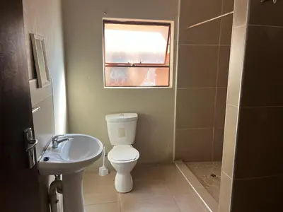 a bathroom with a toilet and a sink and a window at AS contractors accommodation in Erasmus