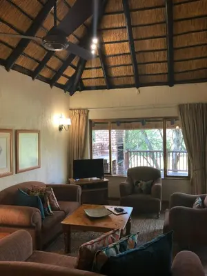 a living room with couches and a table at Ezulwini - Kruger Park Lodge Golf Estate in Hazyview