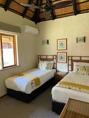 a bedroom with two beds and a window at Ezulwini - Kruger Park Lodge Golf Estate in Hazyview