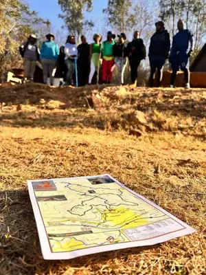 a kite sitting on the ground with people in the background at Ubuntu Hikers Cabin in Waterval Boven