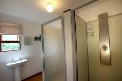 a bathroom with a shower and a sink at Ubuntu Hikers Cabin in Waterval Boven
