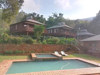 a house with a swimming pool in the yard at Ubuntu Hikers Cabin in Waterval Boven