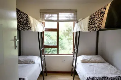 two bunk beds in a room with a window at Ubuntu Hikers Cabin in Waterval Boven