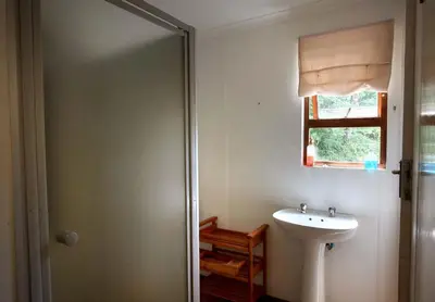 a bathroom with a sink and a window at Ubuntu Hikers Cabin in Waterval Boven