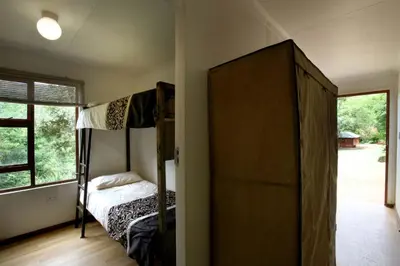 a bedroom with two bunk beds and a window at Ubuntu Hikers Cabin in Waterval Boven