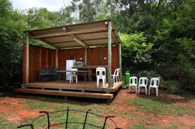 a wooden deck with a table and chairs on it at Ubuntu Hikers Cabin in Waterval Boven