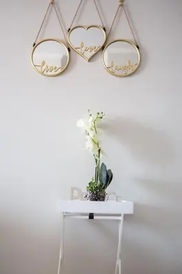 two heart shaped mirrors hanging on a wall with a table at Oasis Comfort Apartment in Midrand