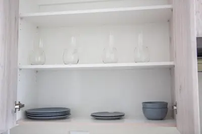 a shelf with plates and bowls in a kitchen at Oasis Comfort Apartment in Midrand