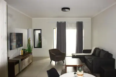 a living room with a couch and a chair at Oasis Comfort Apartment in Midrand