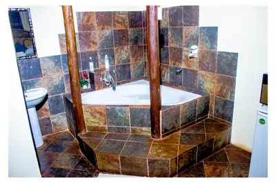 a bathroom with a tub and a sink at Fairy Gardens Lodge in Pretoria