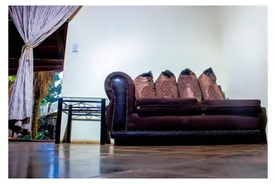 a brown leather couch sitting in a living room at Fairy Gardens Lodge in Pretoria
