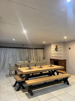 a large room with a large table and benches at Mogoma Guesthouse in Witbank