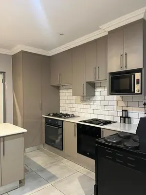 a kitchen with a stove and a microwave at Mogoma Guesthouse in Witbank