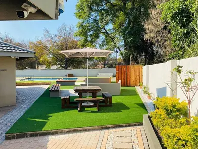 a backyard with a picnic table and green grass at Mogoma Guesthouse in Witbank