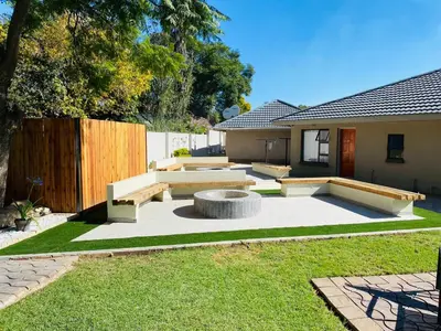 a backyard with a bench in the grass at Mogoma Guesthouse in Witbank