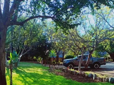 a truck parked in a yard with trees at Bonamanzi Guesthouse in Burgersfort