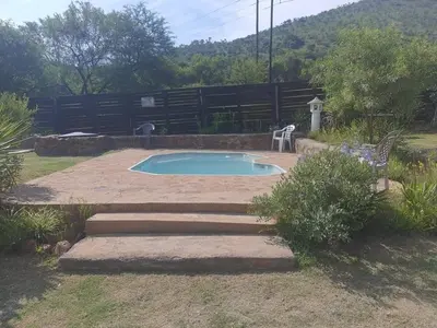 a small swimming pool in a yard with a fence at Chalet 5 At Cynthias Country in Hartbeespoort