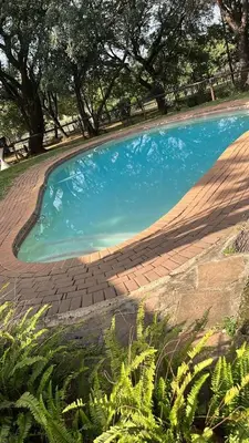 a large pool of blue water in a yard at Chalet 5 At Cynthias Country in Hartbeespoort