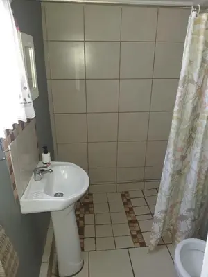 a bathroom with a sink and a shower at Chalet 6 At Cynthias Country in Hartbeespoort