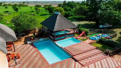an overhead view of a swimming pool with a pavilion at Falcon Lodge PK in Bela-Bela
