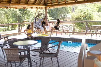 a group of women sitting on a deck next to a pool at Falcon Lodge PK in Bela-Bela