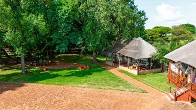 an aerial view of a house with a thatch roof at Falcon Lodge PK in Bela-Bela