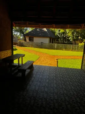 a bench sitting on a patio with a yard at Falcon Lodge Bela in Bela-Bela