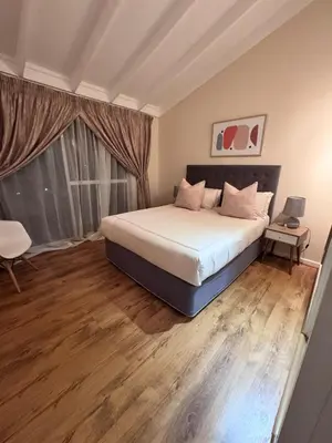 a bedroom with a large bed and a window at Olives by Agnes 33 in Hartbeespoort