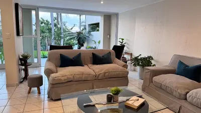 a living room with a couch and a table at Olives by Agnes 33 in Hartbeespoort