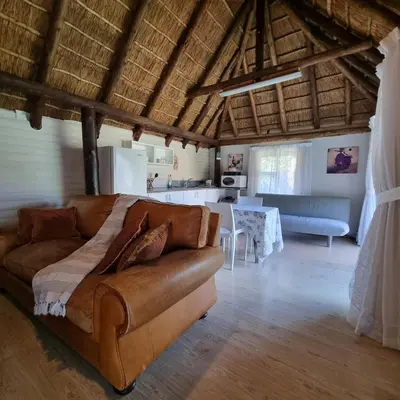 a living room with a couch and a kitchen at Kruin cottage in Pretoria