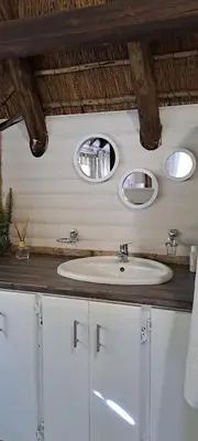a bathroom with a sink and two mirrors at Kruin cottage in Pretoria