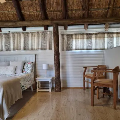 a bedroom with a bed and a table and a couch at Kruin cottage in Pretoria