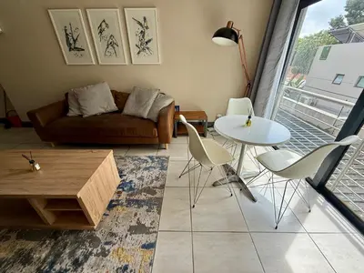 a living room with a couch and a table and chairs at Junction 30 in Pretoria