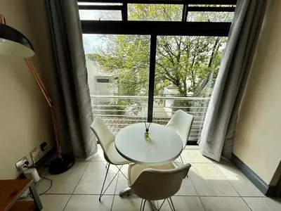 a table and chairs in a room with a large window at Junction 30 in Pretoria