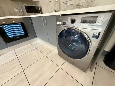 a washing machine in a laundry room with a tile floor at Junction 30 in Pretoria