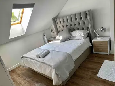 a bedroom with a large bed with a large headboard at Menlo Gate in Pretoria