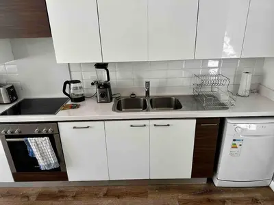 a kitchen with white cabinets and a sink and a dishwasher at Menlo Gate in Pretoria
