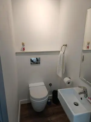 a white bathroom with a toilet and a sink at Menlo Gate in Pretoria