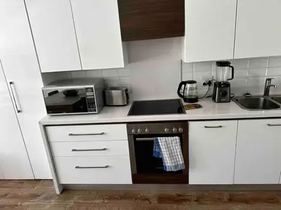 a kitchen with white cabinets and a stove top oven at Menlo Gate in Pretoria
