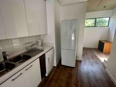 a kitchen with a white refrigerator and a wooden floor at Menlo Gate in Pretoria