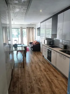 a kitchen and living room with a table and a couch at Menlo Gate in Pretoria